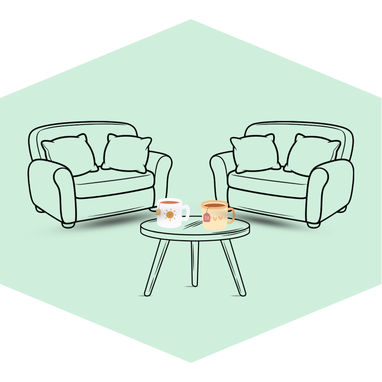 Two comfy sofas and a table with two cups. One has a tea bag labelled 'tea'.